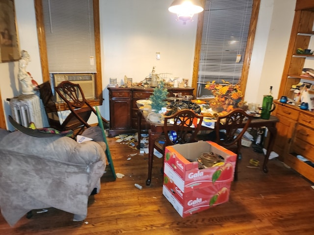 sitting room with radiator, cooling unit, and hardwood / wood-style flooring