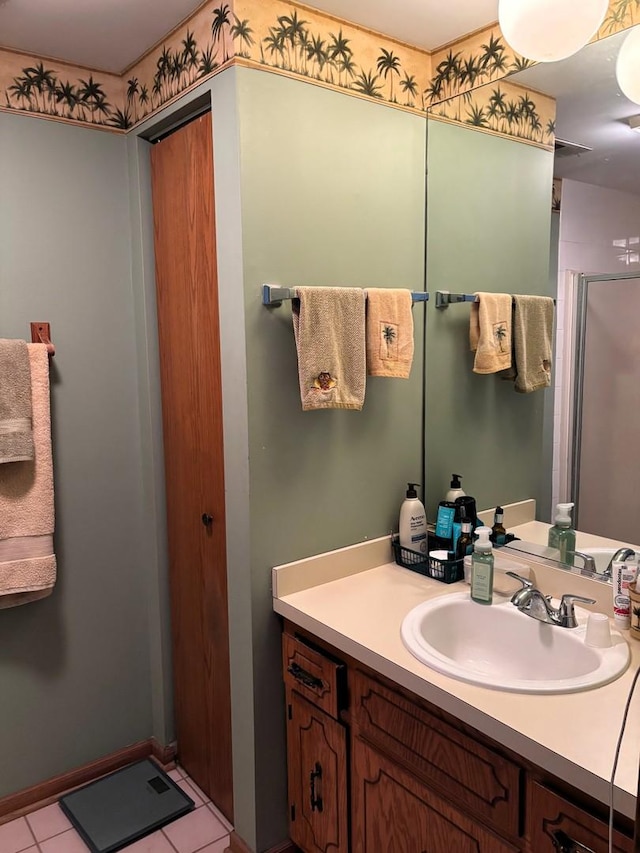 bathroom with tile patterned flooring, vanity, and walk in shower