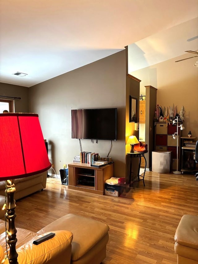 living room with wood-type flooring and ceiling fan