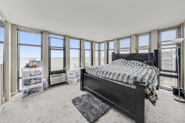 carpeted bedroom featuring floor to ceiling windows, a water view, and multiple windows