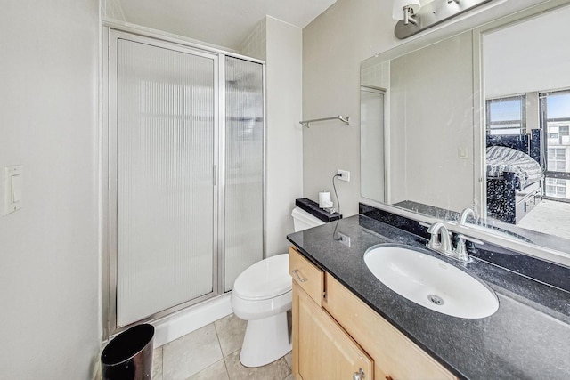 bathroom with toilet, vanity, tile patterned floors, and walk in shower