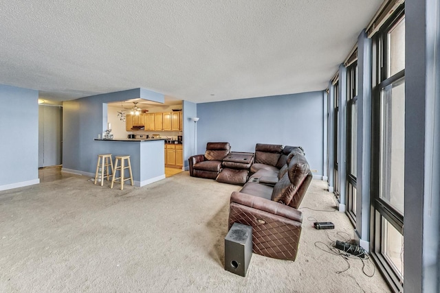 living room featuring ceiling fan and a textured ceiling