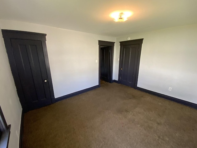 spare room with dark carpet