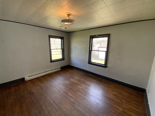 unfurnished room with dark hardwood / wood-style flooring and baseboard heating