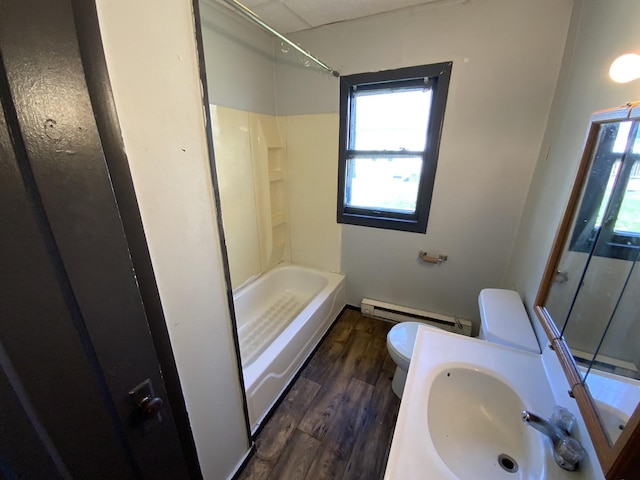 bathroom featuring hardwood / wood-style floors, toilet, baseboard heating, and sink