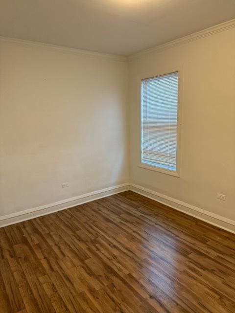 empty room with dark hardwood / wood-style flooring and crown molding