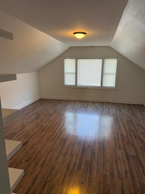 additional living space featuring lofted ceiling and dark hardwood / wood-style floors