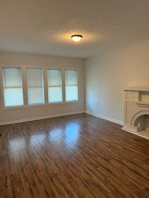 unfurnished living room featuring a textured ceiling, dark hardwood / wood-style floors, and a fireplace