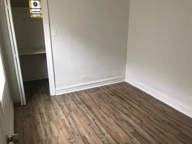 empty room with dark hardwood / wood-style flooring