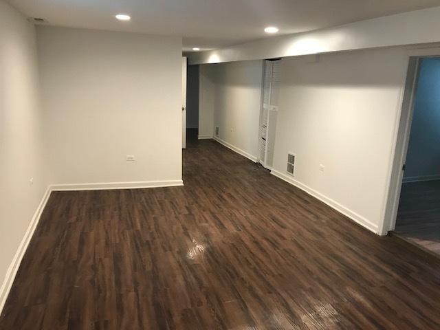 basement with dark hardwood / wood-style floors