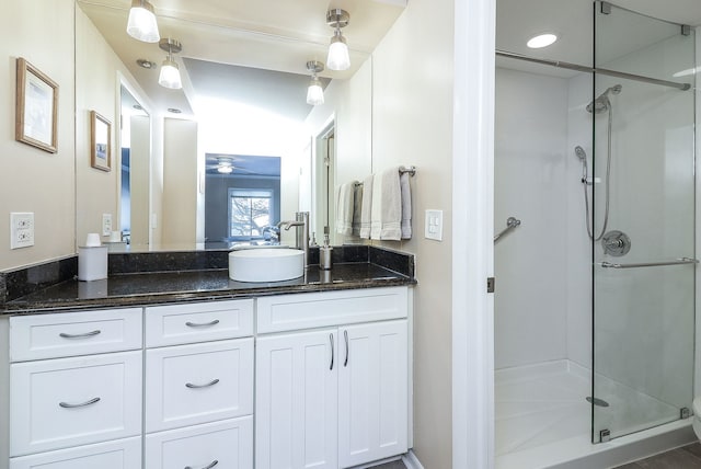 bathroom featuring vanity, ceiling fan, and an enclosed shower