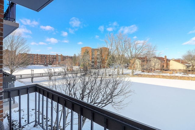 view of snow covered back of property