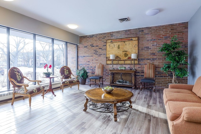 living room with brick wall and hardwood / wood-style floors