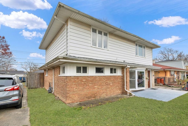 rear view of house with a lawn and a patio area