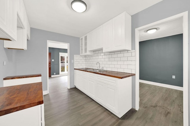 kitchen with sink, white cabinets, dark wood-type flooring, and wood counters