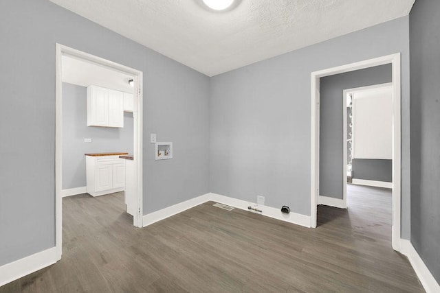 laundry room with washer hookup, dark hardwood / wood-style flooring, and a textured ceiling