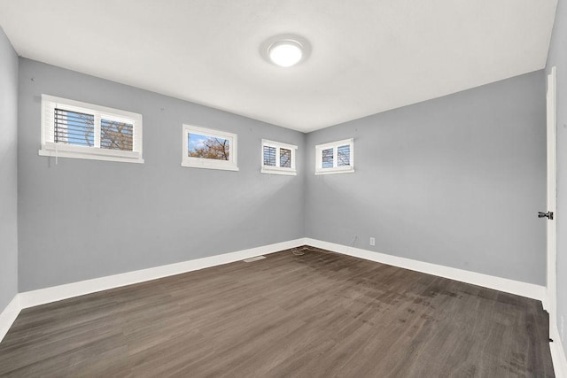 unfurnished room with dark hardwood / wood-style flooring