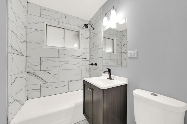 full bathroom with tiled shower / bath, vanity, and toilet