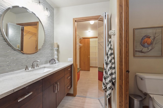 bathroom featuring decorative backsplash, toilet, vanity, and tile patterned flooring