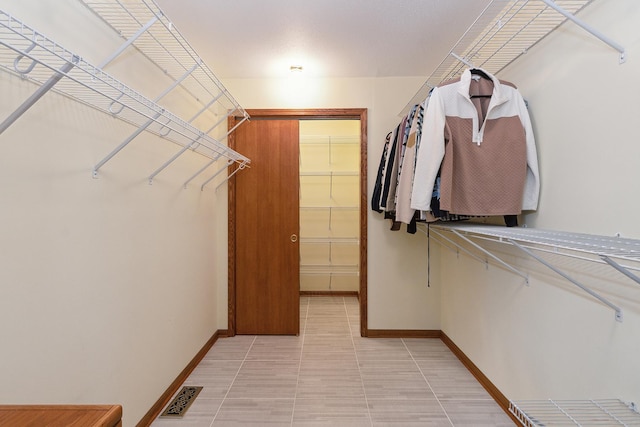 spacious closet featuring light tile patterned flooring