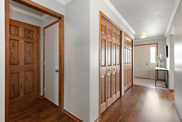 foyer featuring dark hardwood / wood-style flooring, a textured ceiling, and ornamental molding