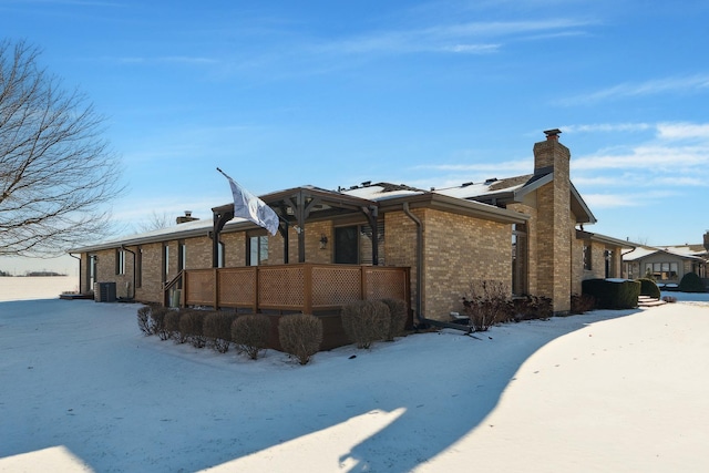 view of snow covered exterior with cooling unit