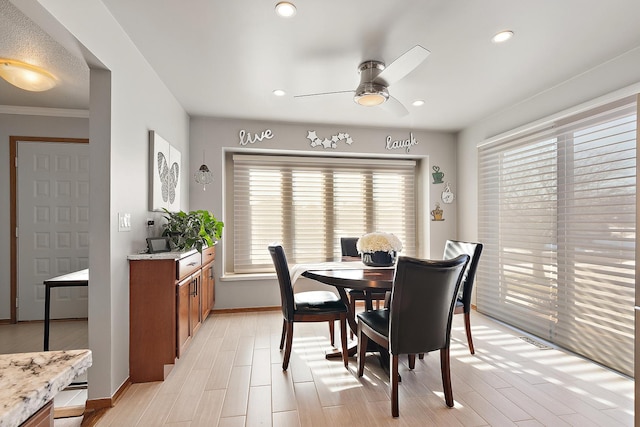 dining space with light wood-type flooring, ceiling fan, and a wealth of natural light