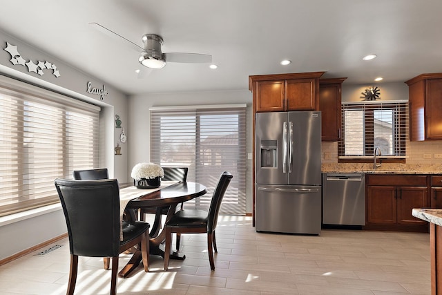 dining space featuring ceiling fan, sink, and a wealth of natural light