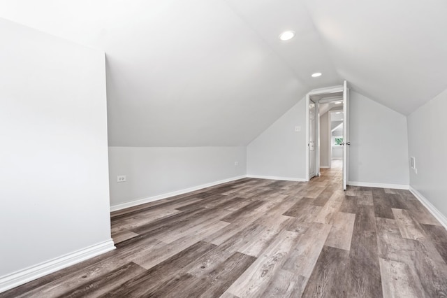 bonus room with wood-type flooring and vaulted ceiling