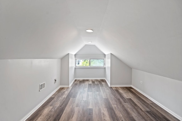 bonus room with vaulted ceiling and dark wood-type flooring