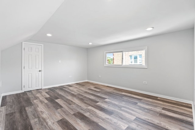 unfurnished room featuring dark hardwood / wood-style floors and vaulted ceiling