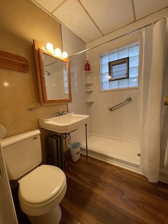 bathroom featuring a paneled ceiling, hardwood / wood-style floors, and walk in shower