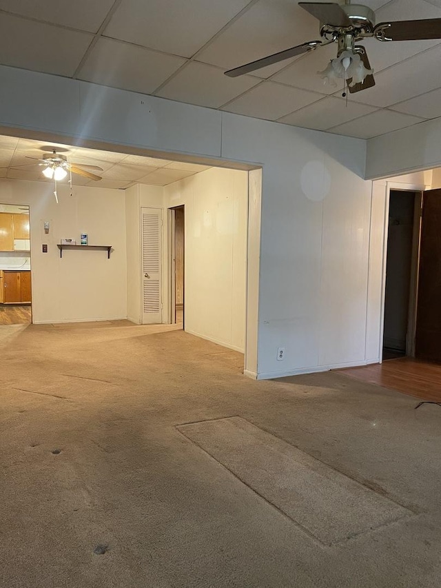 carpeted empty room featuring a paneled ceiling and ceiling fan