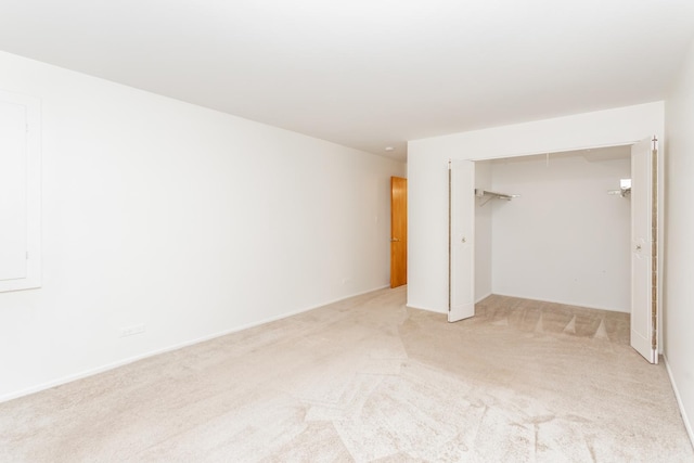 unfurnished bedroom with light colored carpet and a closet