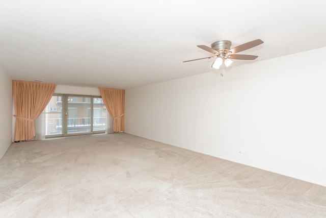 carpeted spare room featuring ceiling fan