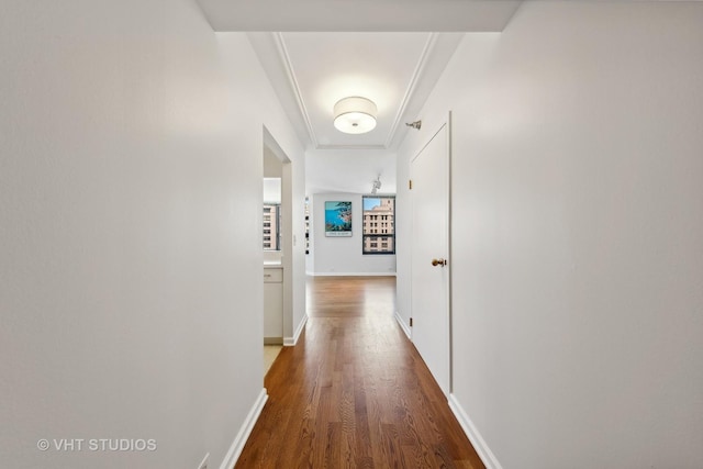 hall with ornamental molding and dark wood-type flooring