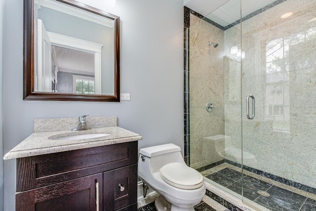 bathroom featuring vanity, toilet, a shower with door, and ornamental molding