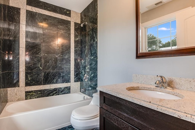 full bathroom with tiled shower / bath combo, toilet, and vanity