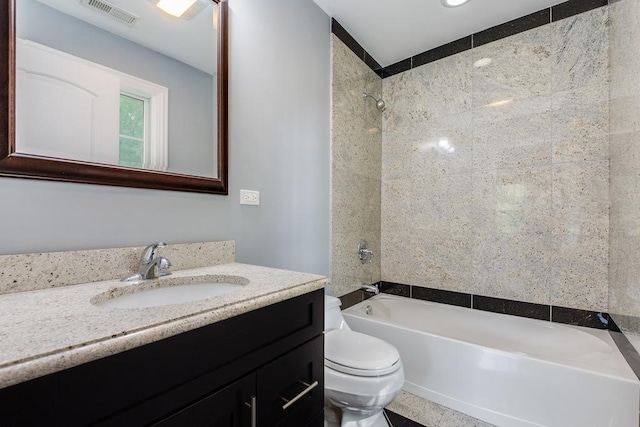 full bathroom with vanity, tiled shower / bath combo, and toilet