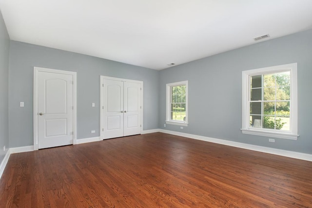 unfurnished bedroom with dark hardwood / wood-style flooring