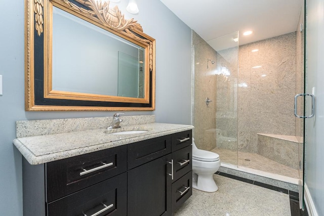 bathroom with vanity, toilet, and a shower with shower door