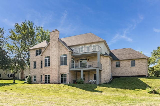 back of house featuring a balcony and a lawn