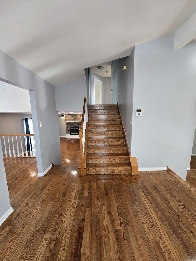 stairway featuring hardwood / wood-style floors and vaulted ceiling