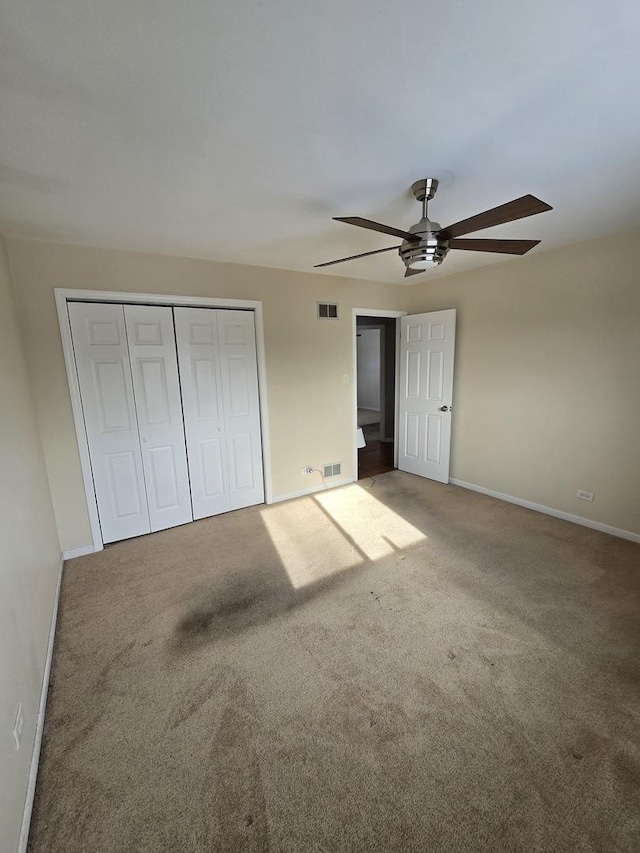 unfurnished bedroom with ceiling fan, carpet floors, and a closet