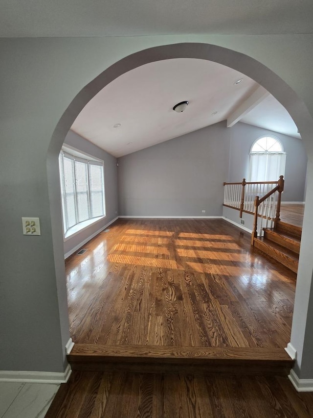 interior space featuring lofted ceiling with beams and dark hardwood / wood-style flooring