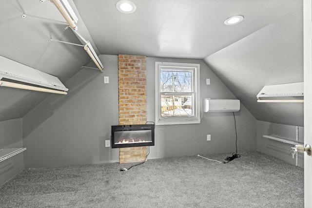 additional living space with carpet flooring, a fireplace, a wall mounted air conditioner, and lofted ceiling