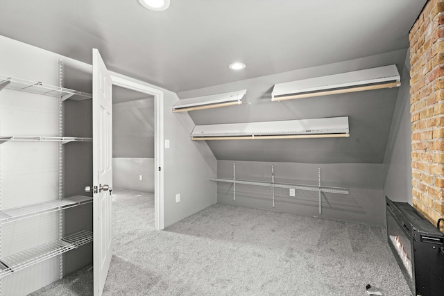 spacious closet with light colored carpet and a wall mounted AC