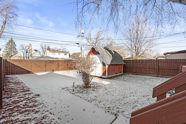 snowy yard featuring a storage shed