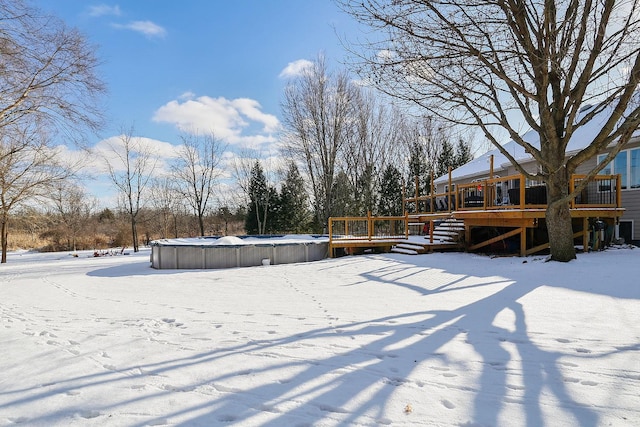 yard layered in snow with a wooden deck