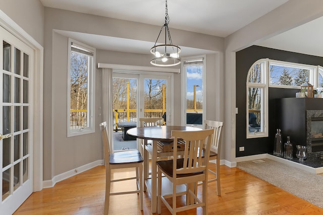 dining space with light hardwood / wood-style flooring and an inviting chandelier